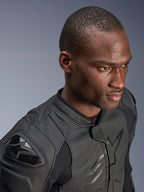 Close-up van een model dat de Alpinestars Dusk Airflow Leren Jas draagt, Black on Black, met uitgebreid geperforeerd leer voor ademend vermogen, externe DFS-schoudersliders en een strak modern ontwerp voor sportief rijden.
