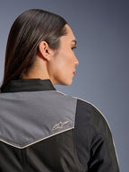 Alpinestars Stella T-Dyno WR jas, motorjas voor dames, zwart, donkergrijs en ecru, close-up achteraanzicht van de schouder met grijs paneel en ecru ster-logo, vintage-geïnspireerde motoruitrusting