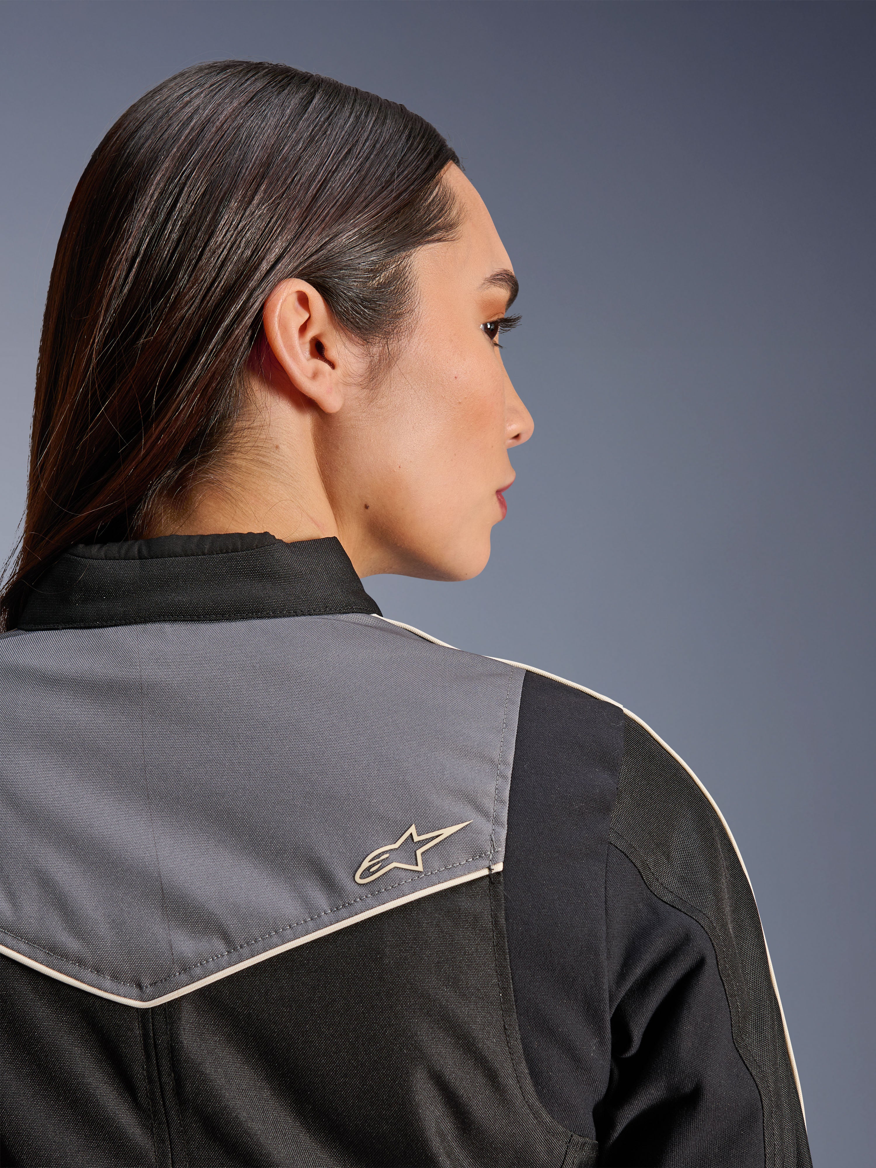 Alpinestars Stella T-Dyno WR jas, motorjas voor dames, zwart, donkergrijs en ecru, close-up achteraanzicht van de schouder met grijs paneel en ecru ster-logo, vintage-geïnspireerde motoruitrusting