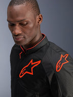 Alpinestars Viper Air V4 Jas, zwart en fluo rood, gedragen door een mannelijk model, close-up weergave met mesh textielpanelen en heldere fluorescerende rode Alpinestars-logo's op de borst en schouder, sportieve motoruitrusting