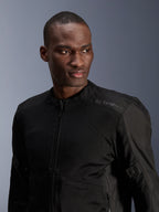 Alpinestars C-1 Air Jacket, zwarte urban motorjas met tech mesh panelen, gedragen door een model, voorzien van een subtiel hitteoverdracht Alpinestars-logo op de schouder, ontworpen voor luchtstroom en lichtgewicht comfort bij warm weer