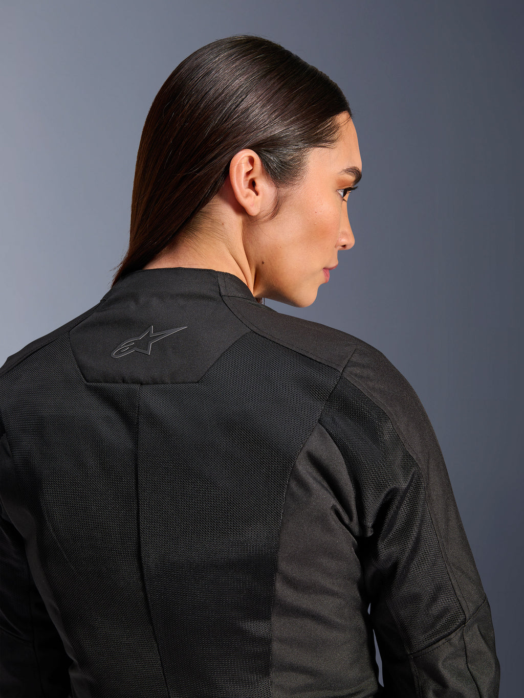 Alpinestars Stella C-1 Air damesmotorjas, textiele motorjas, zwart, close-up achteraanzicht met tech mesh ventilatiepanelen en een reflecterend sterlogo op de bovenrug, moderne stedelijke motoruitrusting