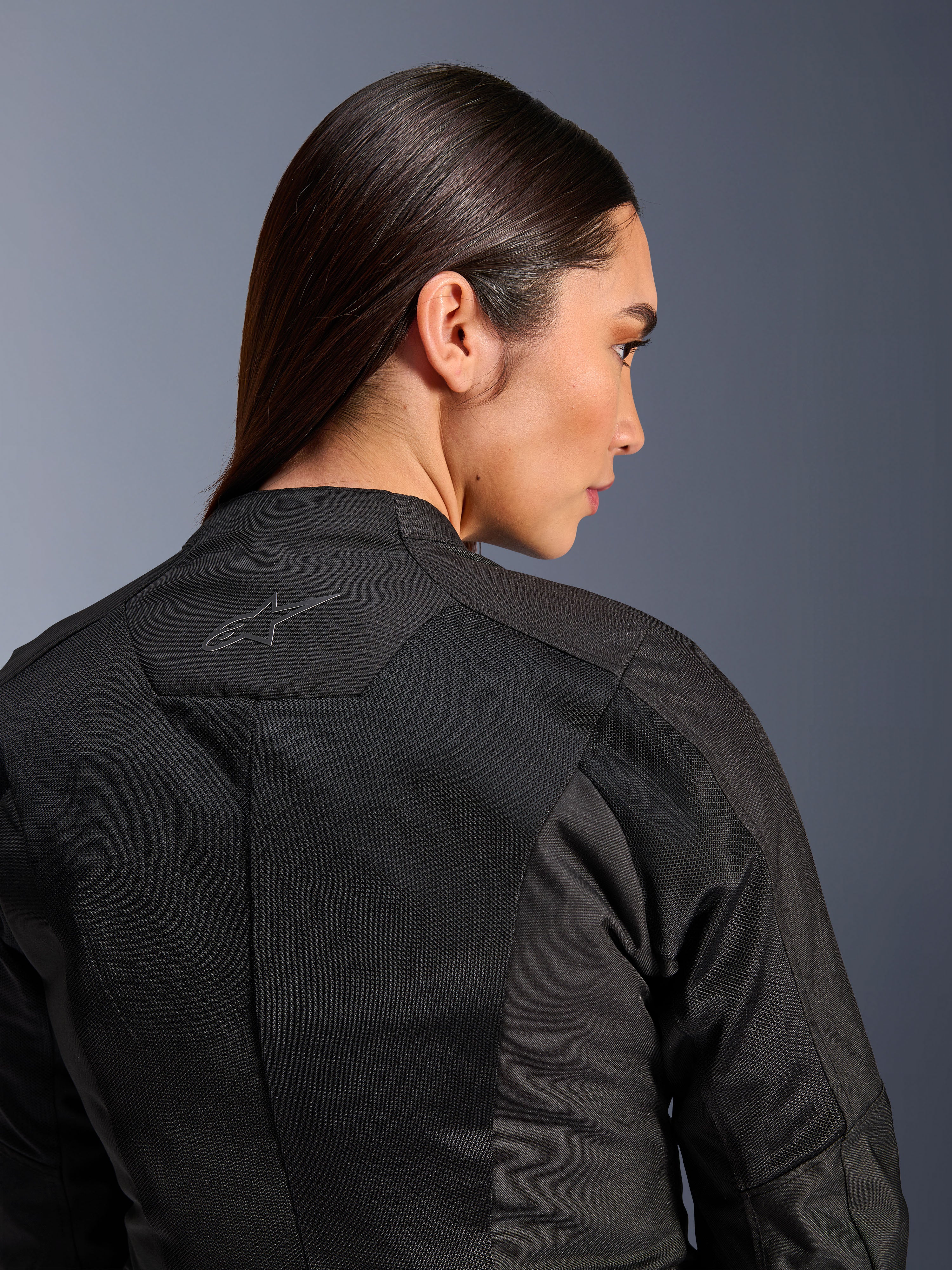 Alpinestars Stella C-1 Air damesmotorjas, textiele motorjas, zwart, close-up achteraanzicht met tech mesh ventilatiepanelen en een reflecterend sterlogo op de bovenrug, moderne stedelijke motoruitrusting
