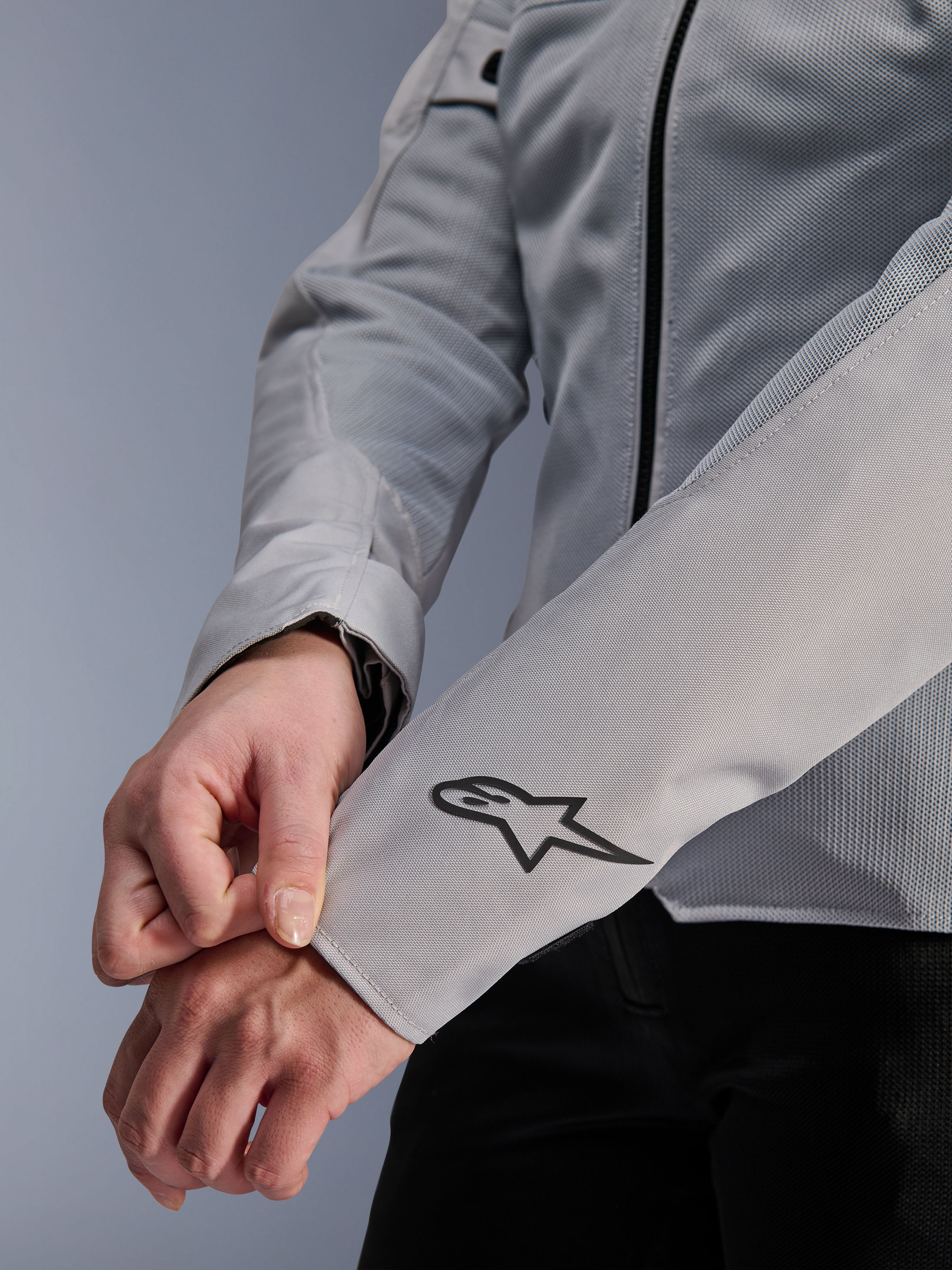 Close-up van de Alpinestars Stella C-1 Air motorjas in Silver, met technische mesh-constructie en een zwart Alpinestars-logo op de linkermouw, urban motorjas voor dames met reflecterende branding