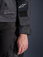 Alpinestars Molly Air jas, close-up detail van zwart ripstop-textiel, wit Astar-logo op mouwzak met klittenbandpatch, verstelbare manchet en geprinte merktekst aan de zijkant, urban motorkleding voor dames