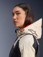 Alpinestars Molly Air Jacket, Black Almond, eigentijdse stedelijke motorjas, zijaanzicht van model met de capuchon op, Alpinestars-logo en oranje koordaccenten, ripstop stoftextuur