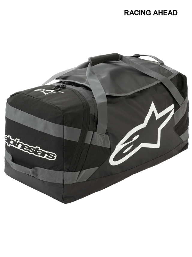 Alpinestars Goanna Bag, motorcross duffeltas, zwart en antracietgrijs met witte logo's, voorzien van groot sterlogo aan de zijkant en tekstlogo, duurzame basis van zeildoek, versterkte draagbanden, grote opbergruimte voor off-road race-uitrusting