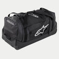 Alpinestars Komodo Reistas, grote motorcross uitrustingstas in zwart en antraciet met witte logo's, voorzien van wielen en een telescopisch handvat, duurzame constructie voor transport van race-uitrusting