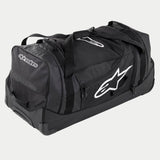 Alpinestars Komodo Reistas, grote motorcross uitrustingstas in zwart en antraciet met witte logo's, voorzien van wielen en een telescopisch handvat, duurzame constructie voor transport van race-uitrusting