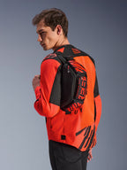 Alpinestars MM93 Waist Bag, heuptas, zwart met Red Fluo en Bright Red, door een model over de rug gedragen over een rood-zwarte motorjas, voorzien van opvallende MM93-branding en Marc Marquez-graphics