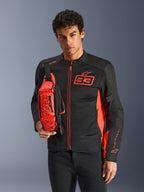 Alpinestars MM93 Waist Bag, heuptas gedragen als crossbodytas, fluo rood en zwart, man draagt bijpassend zwart en rood motorjack, voorzien van Marc Marquez 93-logo, sportief race-ontwerp