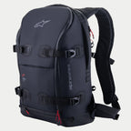 Alpinestars AMP-7 rugzak, technische motorrugzak, zwart met rode ritsaccenten, voorzien van vier verstelbare compressieriemen met gespen, gestructureerde gewatteerde wanden, Alpinestars-logo op de bovenkant en merknaam op de zijkant, ergonomische schouderbanden voor adventure en road touring.