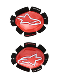 Alpinestars GP Tech kniesliders, rood en wit, motorrace kniebeschermers, groot wit sterlogo op glanzend rood kunststof, 'ONE GOAL. ONE VISION.' tekst op zwarte bloemblad-vormige klittenband bevestiging, set van links en rechts voor circuitgebruik