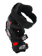Alpinestars RK-7 Plasma kniebrace, motocross kniebeschermer, zwart en rood, zijaanzicht met het asymmetrische vezelversterkte frame, vierpuntscharniersysteem en gevoerde X-banden met witte Astar-logo's