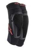 Alpinestars Bionic Flex kniebeschermers, zwart en rood, paar motorcross kniebeschermers met geperforeerde Nucleon Flex Technology-beschermers, rode Astars-logo's en elastische banden op een ademende zwarte mesh sleeve.