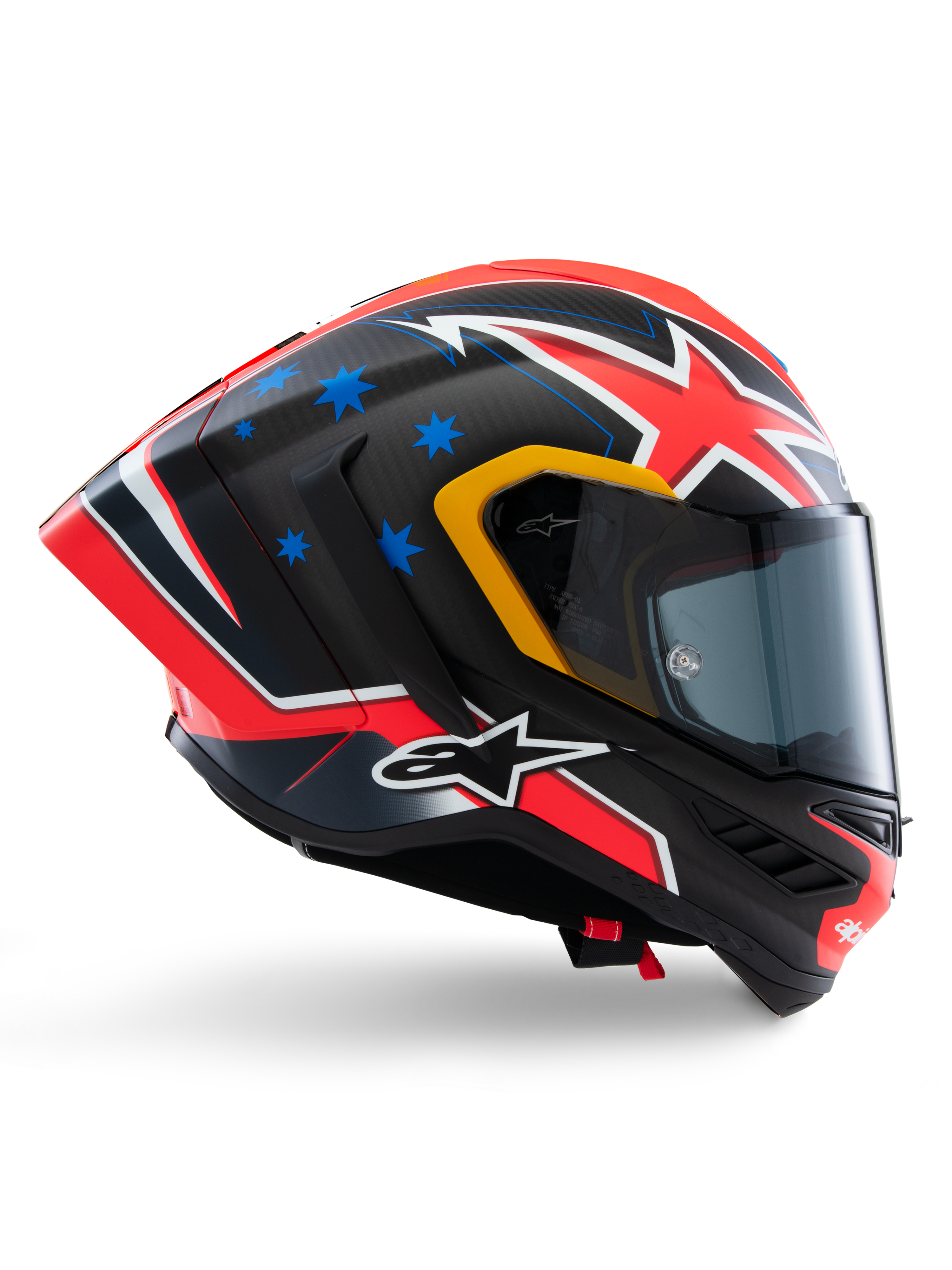 Alpinestars Supertech R10 Miller Limited Edition helm, integraal racehelm, mat carbon met rood, wit en blauwe graphics, blauwe steraccenten en gele vizierrand, aerodynamisch profiel met donker rookvizier, hoogwaardige motorveiligheidsuitrusting