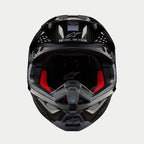 Alpinestars Supertech M10 Solid helm, motorcrosshelm, glanzend zwart carbon, vooraanzicht met rode binnenvoering, koolstofvezel helmschaal en 'ONE GOAL. ONE VISION.' slogan op het viziergedeelte