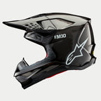 Alpinestars Supertech M10 Solid helm, motorcrosshelm, zwart glanzend carbon, zijprofiel met zichtbaar carbonweefsel, wit SM10-logo en Alpinestars-logo, gestroomlijnd aerodynamisch ontwerp met ventilatieopeningen bedekt met gaas