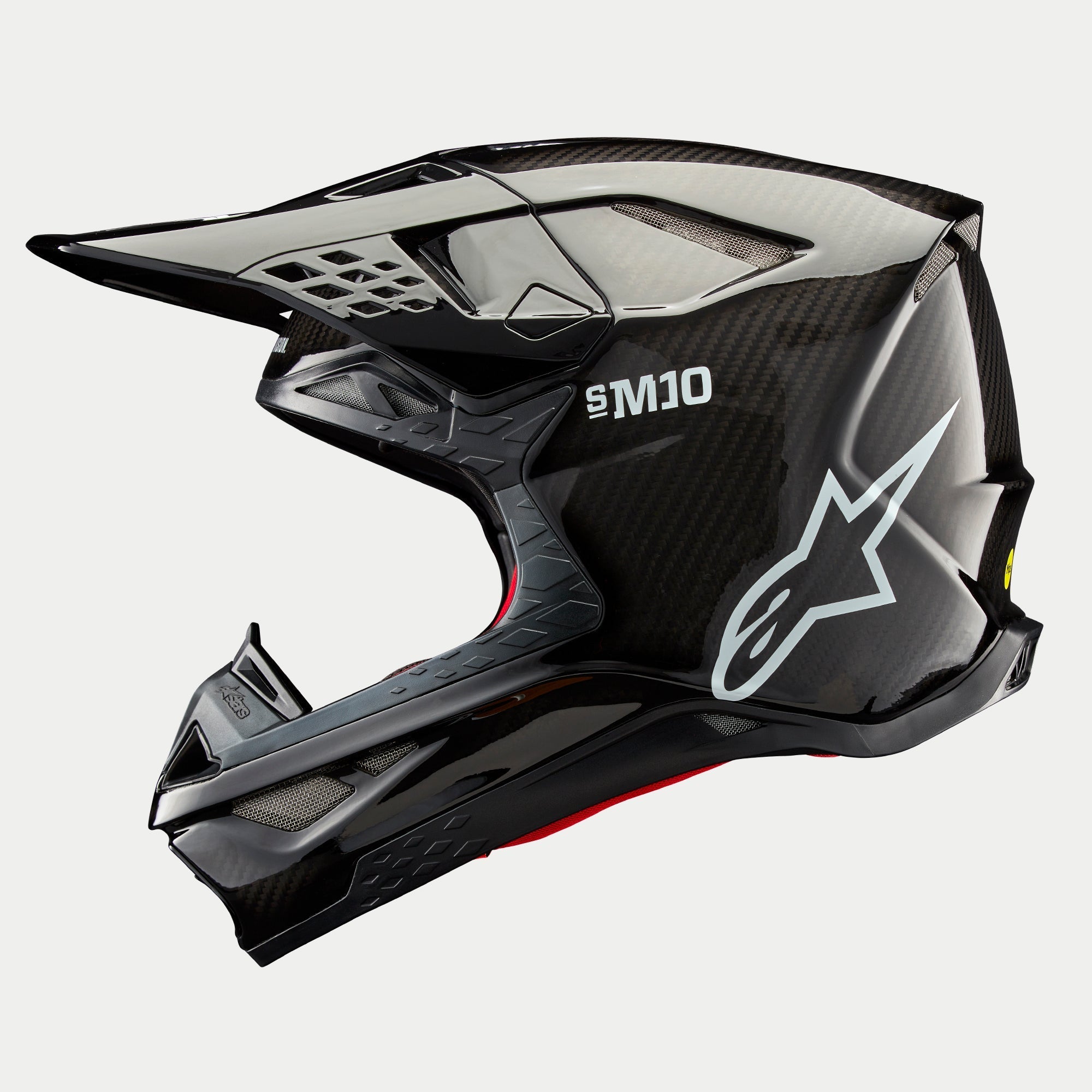 Alpinestars Supertech M10 Solid helm, motorcrosshelm, zwart glanzend carbon, zijprofiel met zichtbaar carbonweefsel, wit SM10-logo en Alpinestars-logo, gestroomlijnd aerodynamisch ontwerp met ventilatieopeningen bedekt met gaas