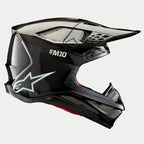 Alpinestars Supertech M10 Solid Helm, Black Glossy Carbon, motorcrosshelm, zijaanzicht met glanzend koolstofvezel weefsel, S-M10 branding, wit Alpinestars sterlogo, aerodynamisch ontwerp met klep en ventilatieopeningen