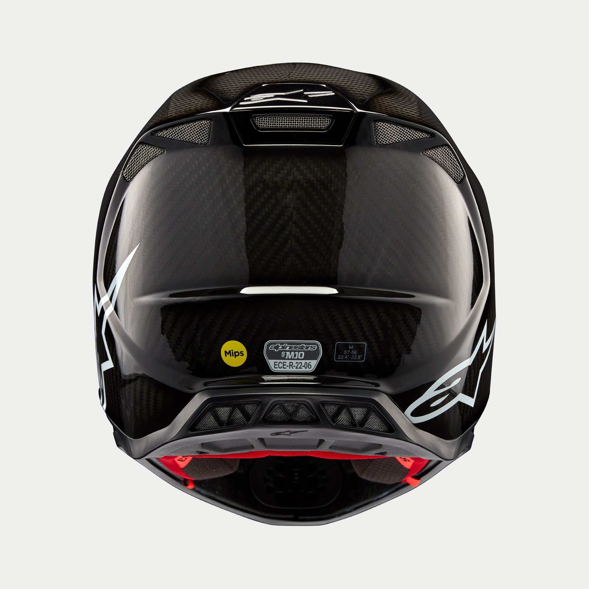 Alpinestars Supertech M10 Solid Helm, zwart glanzend carbon, achteraanzicht met glanzend koolstofvezelpatroon, wit Alpinestars-logo, MIPS- en ECE-certificeringsstickers, aerodynamische vorm met ventilatieopeningen