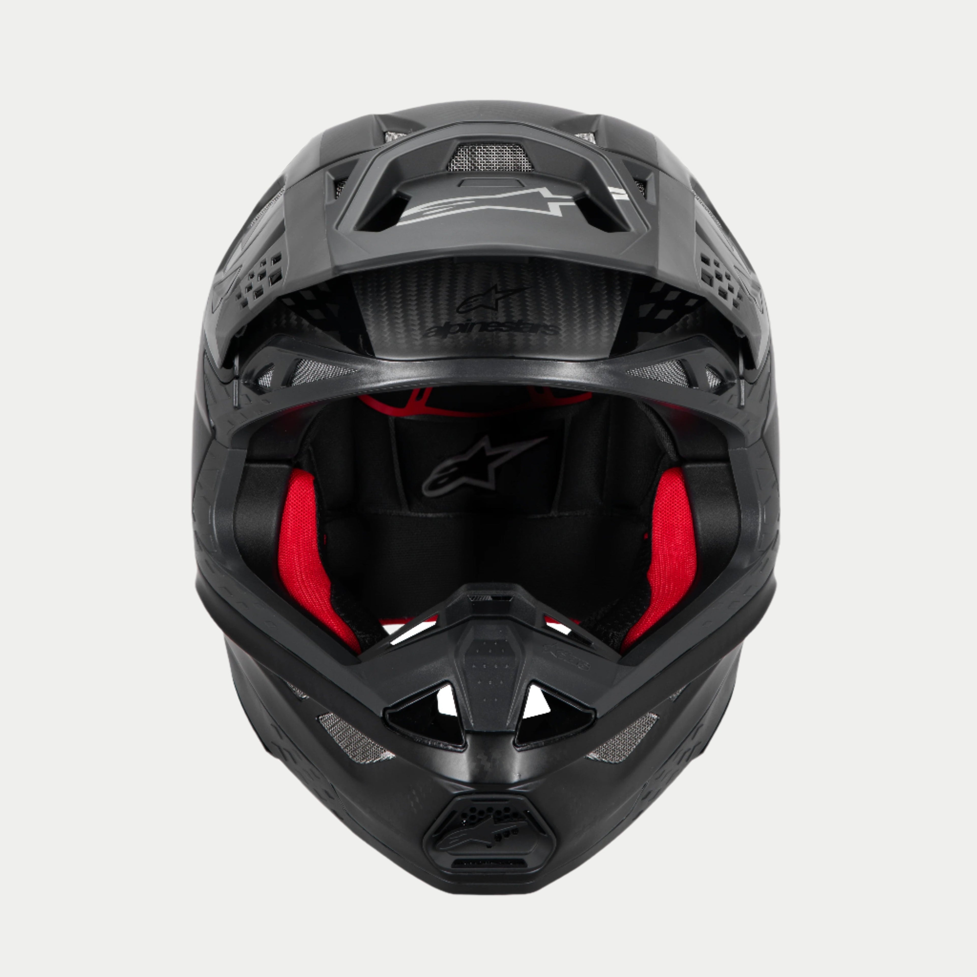 Alpinestars Supertech M10 Fame ECE 22.06 helm, motorcrosshelm, zwart carbon mat en glanzend, vooraanzicht met zichtbare rode binnenvoering, aerodynamische koolstofvezel schaal, geventileerd ontwerp voor off-road racen