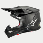 Alpinestars Supertech M10 Fame ECE 22.06 helm, zijaanzicht, mat en glanzend zwarte carbon-afwerking, voorzien van zichtbaar koolstofvezelweefsel, zilveren Astars-logo op de zijkant, aerodynamisch ontwerp met geïntegreerde ventilatieopeningen en zwart vizier