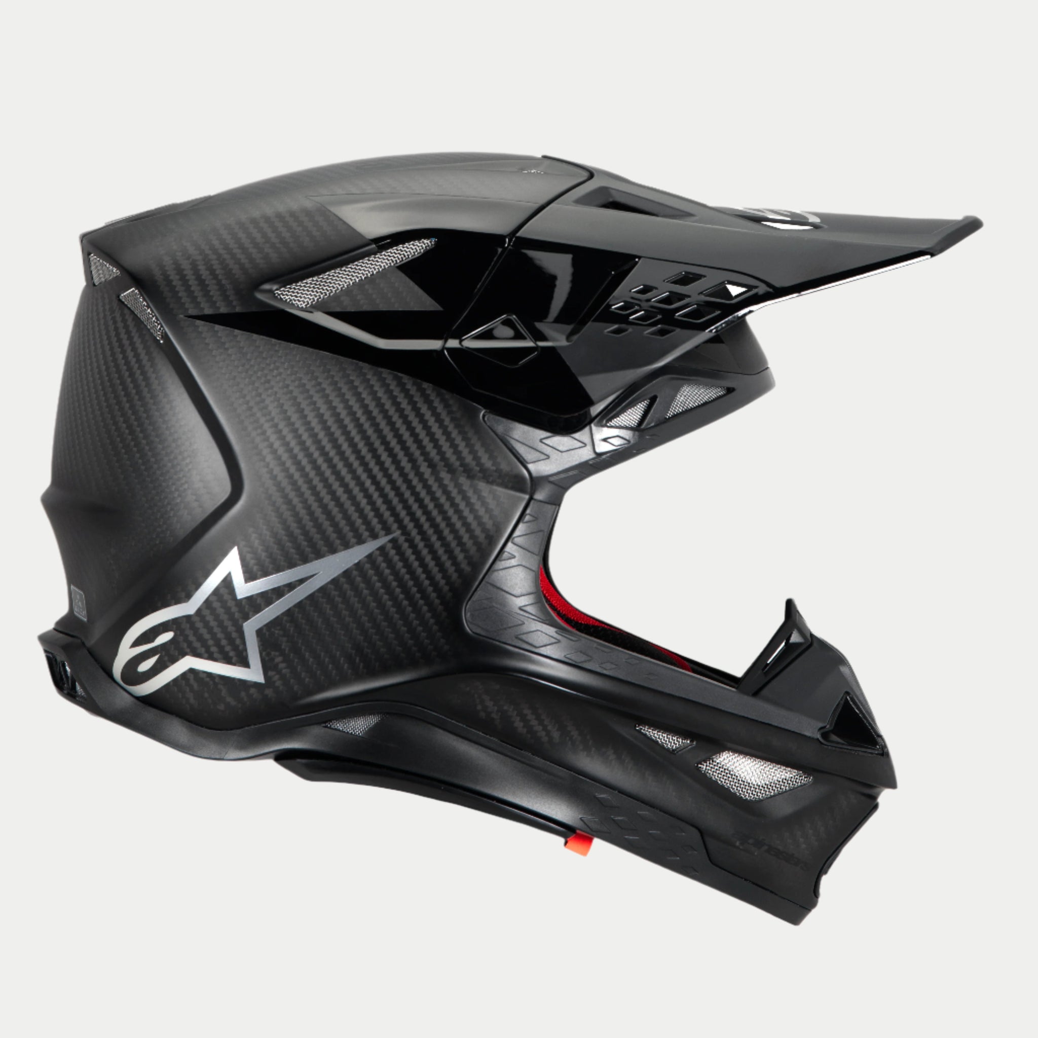 Alpinestars Supertech M10 Fame Helmet, Motocross Helmet, Black Carbon Matte and Glossy, side profile highlighting carbon fiber weave and silver Astars logo, aerodynamic design with multiple mesh-covered ventilation ports, high-performance off-road head protection