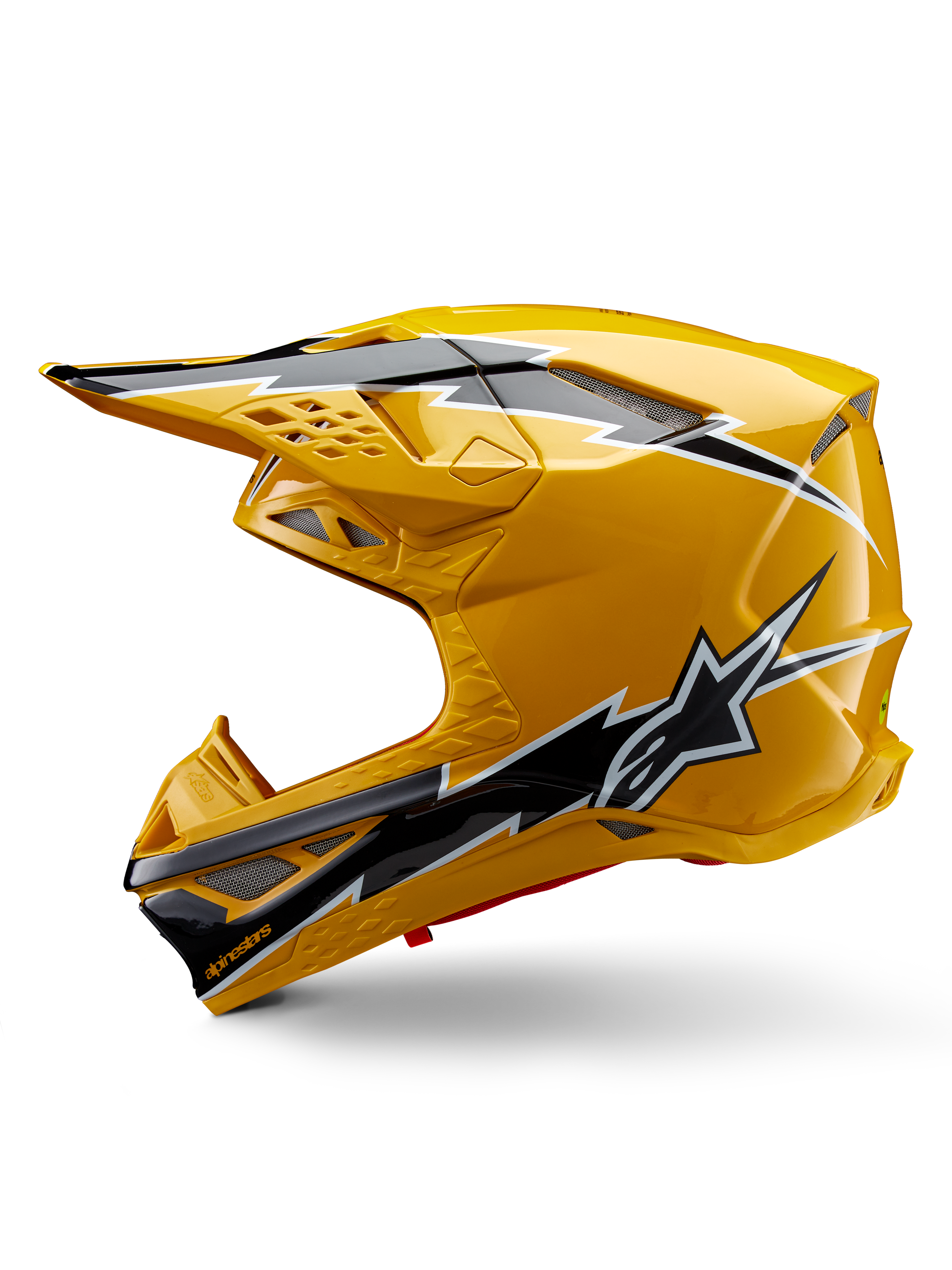 Alpinestars Supertech M10 Ampress helm, motorcrosshelm, glanzend geel met zwart-witte graphics, zijaanzicht met opvallende hoekige ontwerpen, Alpinestars sterlogo en meerdere ventilatieopeningen met zilverkleurig gaas, professionele off-road race-uitrusting