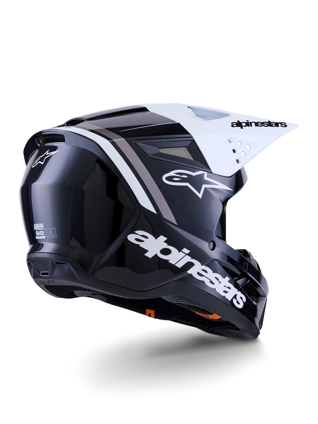 Alpinestars S-M3 Radium helm, motorcrosshelm, zwart, wit en grijs glanzend, achter-zijaanzicht met wit vizier, met opvallend Alpinestars-logo op de zijkant en achterkant, gestroomlijnde aerodynamische schaal met ventilatiegaas, ontworpen voor off-road motorcross en enduro