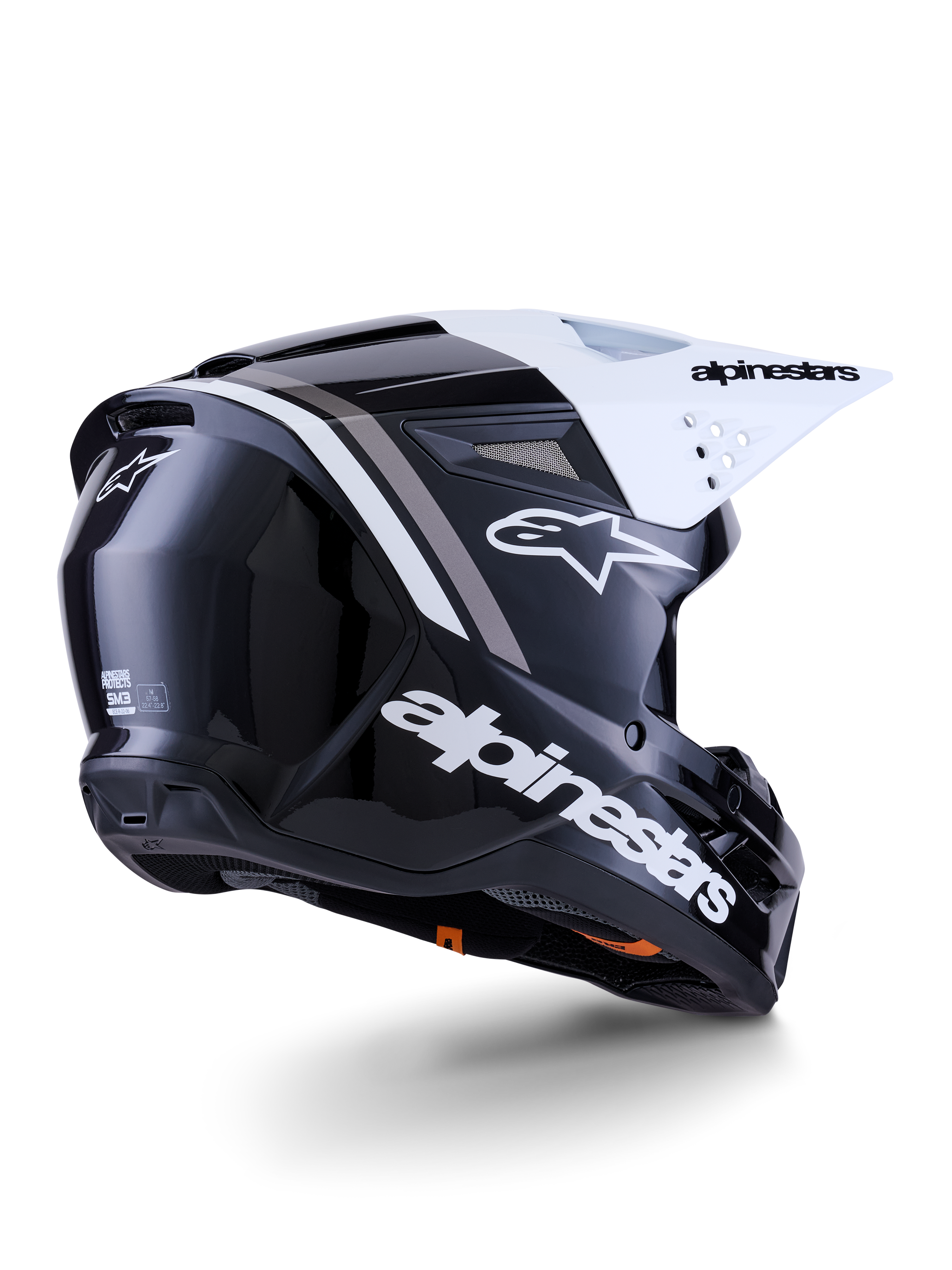 Alpinestars S-M3 Radium helm, motorcrosshelm, zwart, wit en grijs glanzend, achter-zijaanzicht met wit vizier, met opvallend Alpinestars-logo op de zijkant en achterkant, gestroomlijnde aerodynamische schaal met ventilatiegaas, ontworpen voor off-road motorcross en enduro
