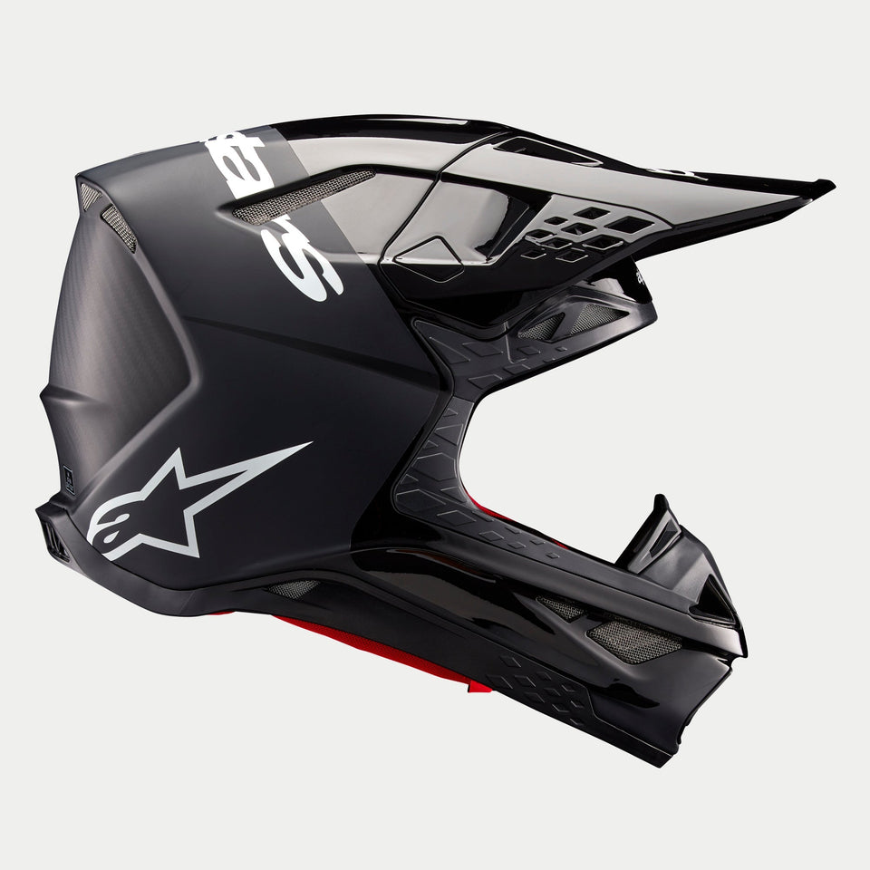 Alpinestars Supertech M10 Flood Helmet ECE, Motocross Helmet, Black and Dark Gray with Matte and Glossy finish, side profile view featuring aerodynamic design, integrated visor, and white Alpinestars branding