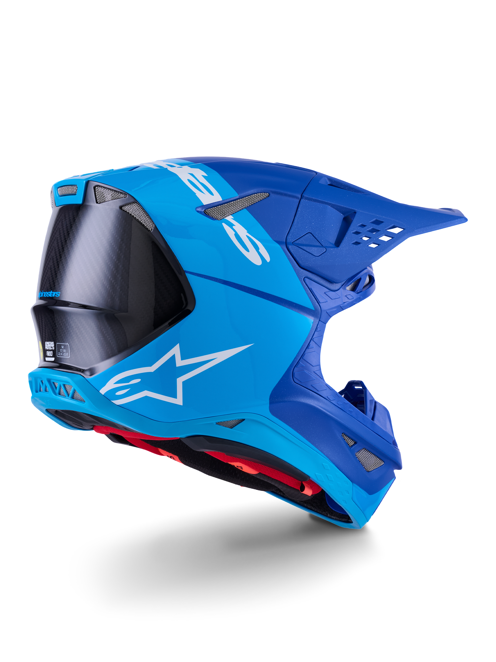 Alpinestars Supertech M10 Flood Helm, motocrosshelm, felblauw en marineblauw met zichtbaar zwart koolstofvezel, profiel achter-zijkant met ventilatieopeningen en wit logo, rode binnenvoering, geavanceerd aerodynamisch ontwerp voor off-road prestaties