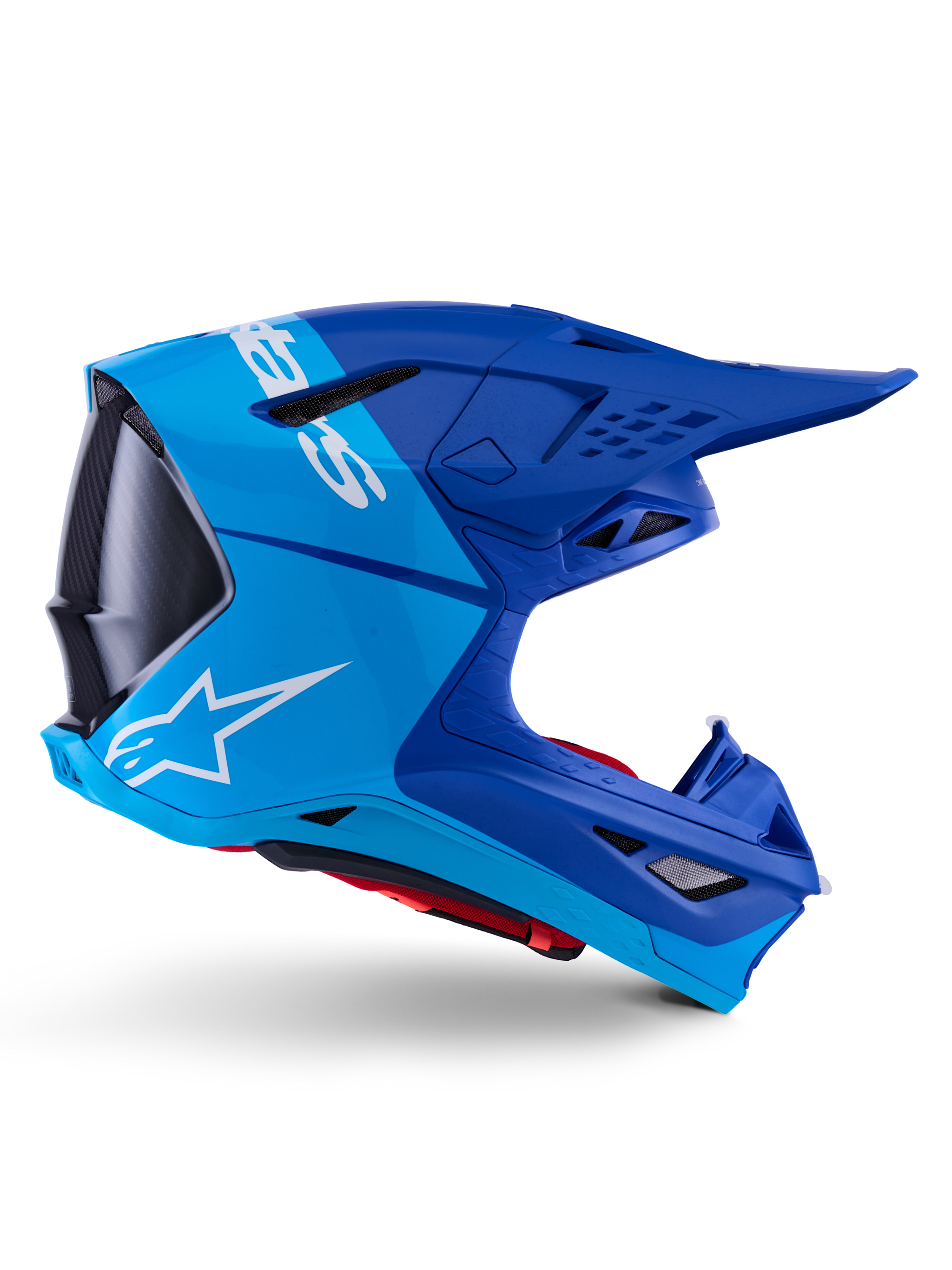 Alpinestars Supertech M10 Flood helm, motocrosshelm, metallic en medium blauw met zwarte carbon accenten, zijaanzicht, voorzien van een wit logo, aerodynamisch ontwerp met ventilatieopeningen, carbon fiber textuurdetails, professionele off-road racebescherming