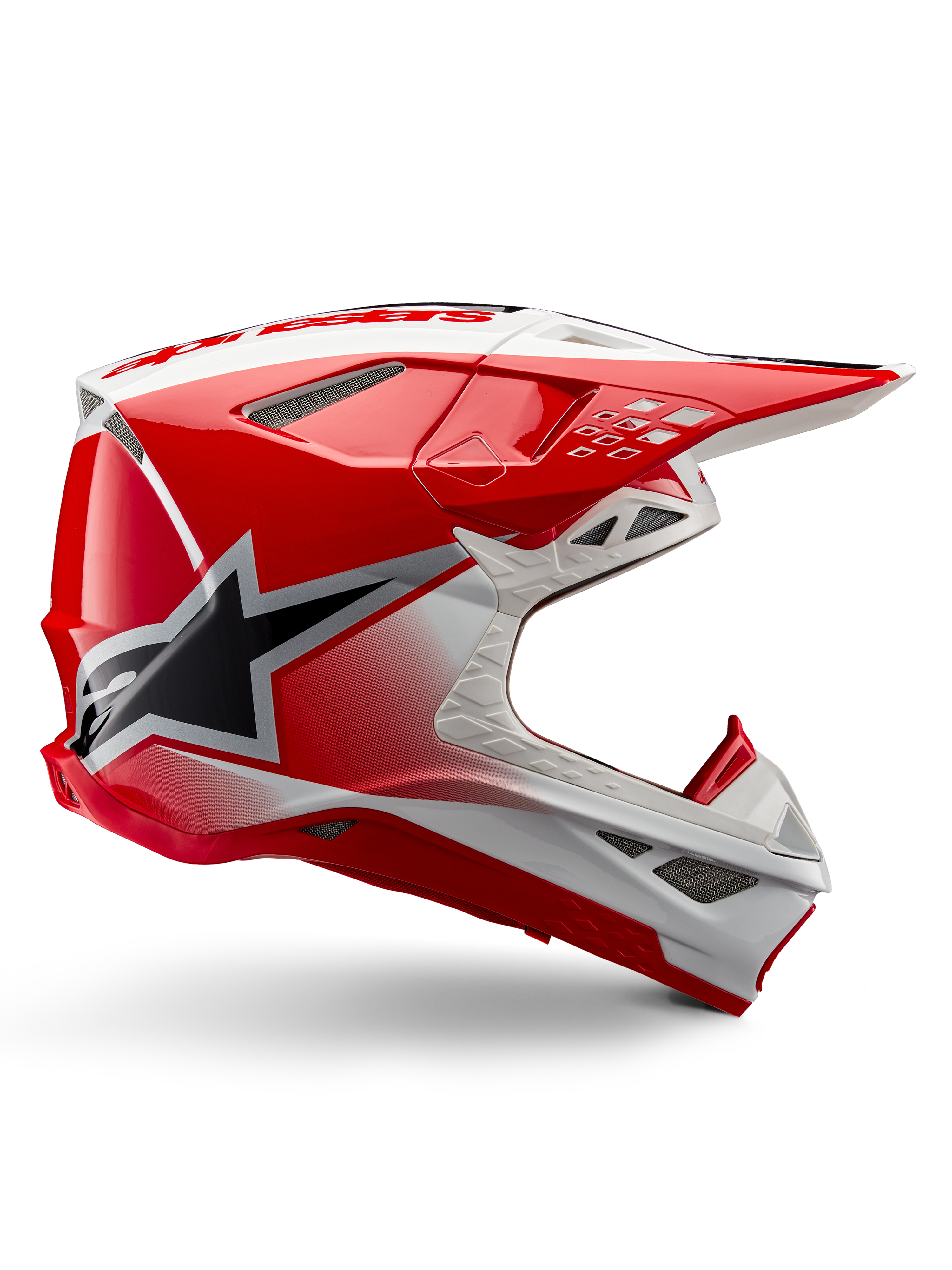 Alpinestars Supertech M10 Unite helm, motorcross racehelm, rood en wit glanzend, zijaanzicht met hoekige geometrische patronen, zwarte ster-graphic, meerdere mesh ventilatieopeningen, aerodynamisch ontwerp voor off-road racing