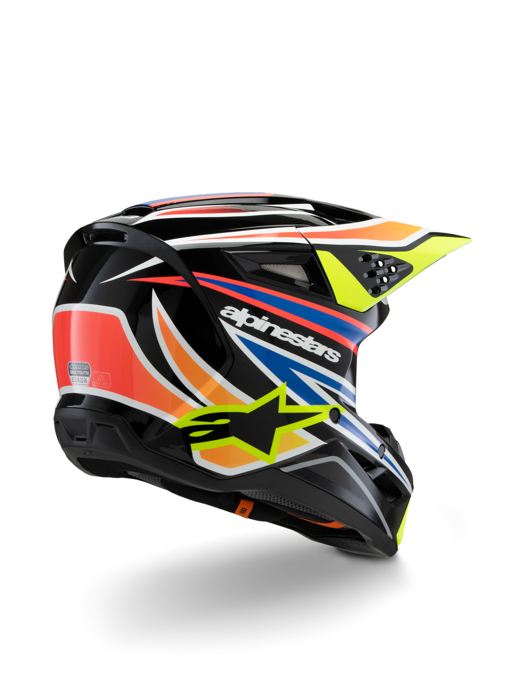 Alpinestars S-M3 Youth Wurx helm, jeugd motorcrosshelm, zwart met levendig oranje, rode, blauwe en fluorescerend gele accenten, driekwart achteraanzicht met aerodynamische schaal en ventilatieopeningen, glanzende afwerking met opvallende Alpinestars-branding