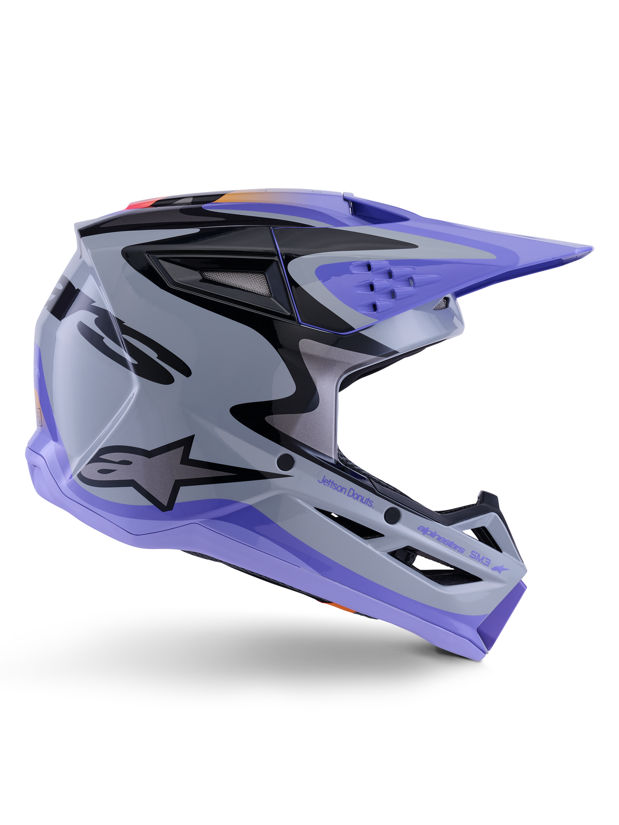 Alpinestars S-M3 Jettson Helm ECE 22.06, motorcrosshelm, grijs, paars en zwart glanzend, zijaanzicht met een paars vizier en kinstuk, slanke aerodynamische schaal met zwarte graphics, meerdere ventilatieopeningen en 'Jettson Donuts' branding aan de zijkant