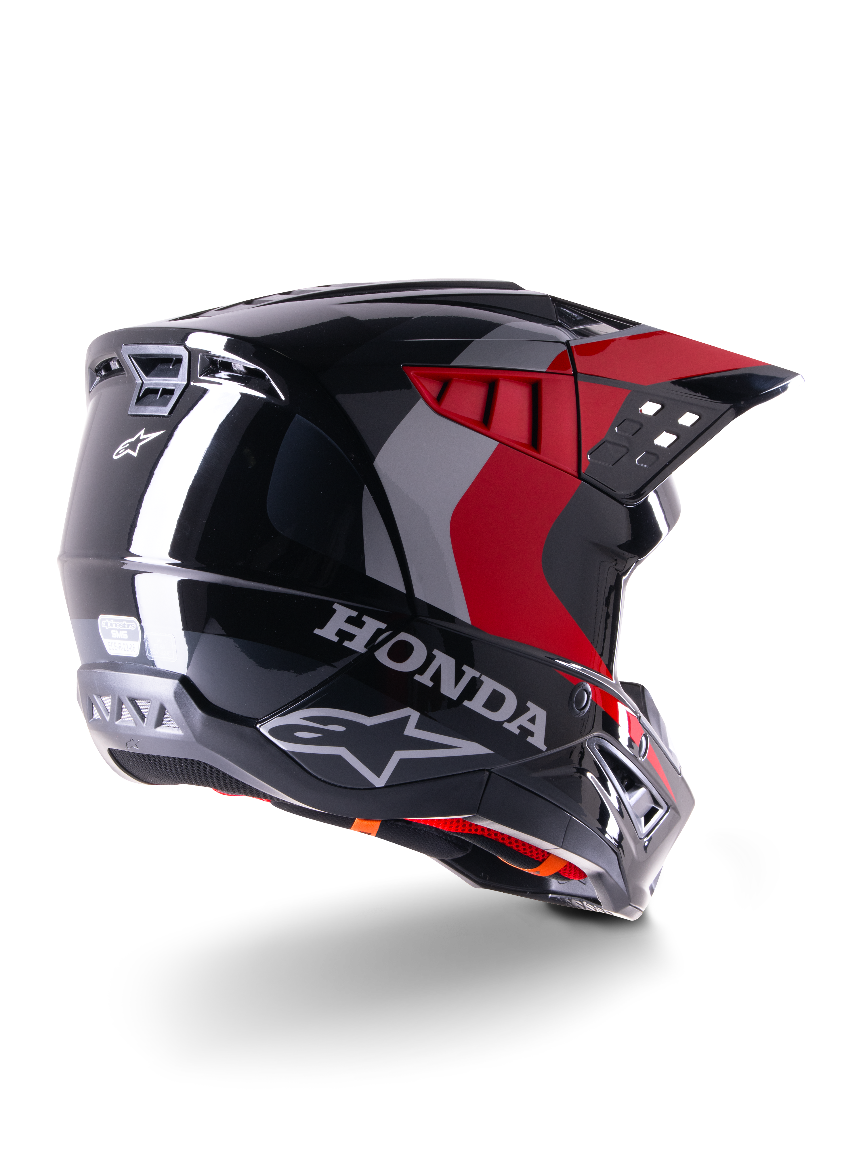 Alpinestars Honda S-M5 ECE helm, motorcrosshelm, glanzend zwart met rood, driekwart achteraanzicht met Honda-branding en Alpinestars-logo's, rode en grijze grafische accenten, ontworpen voor off-road bescherming