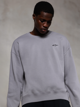 Alpinestars Essentials Ageless Crew, zilverkleurig premium sweatshirt met ronde hals, voorzien van een klein zwart Alpinestars-logo op de borst, gedragen door een model, casual lifestyle streetwear met een zachte fleece textuur.