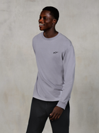 Alpinestars Essentials Ageless LS Tee, Long Sleeve T-Shirt, Silver, small black logo on the chest, worn by a smiling model with dark pants, relaxed contemporary fit, casual motorsport lifestyle apparel