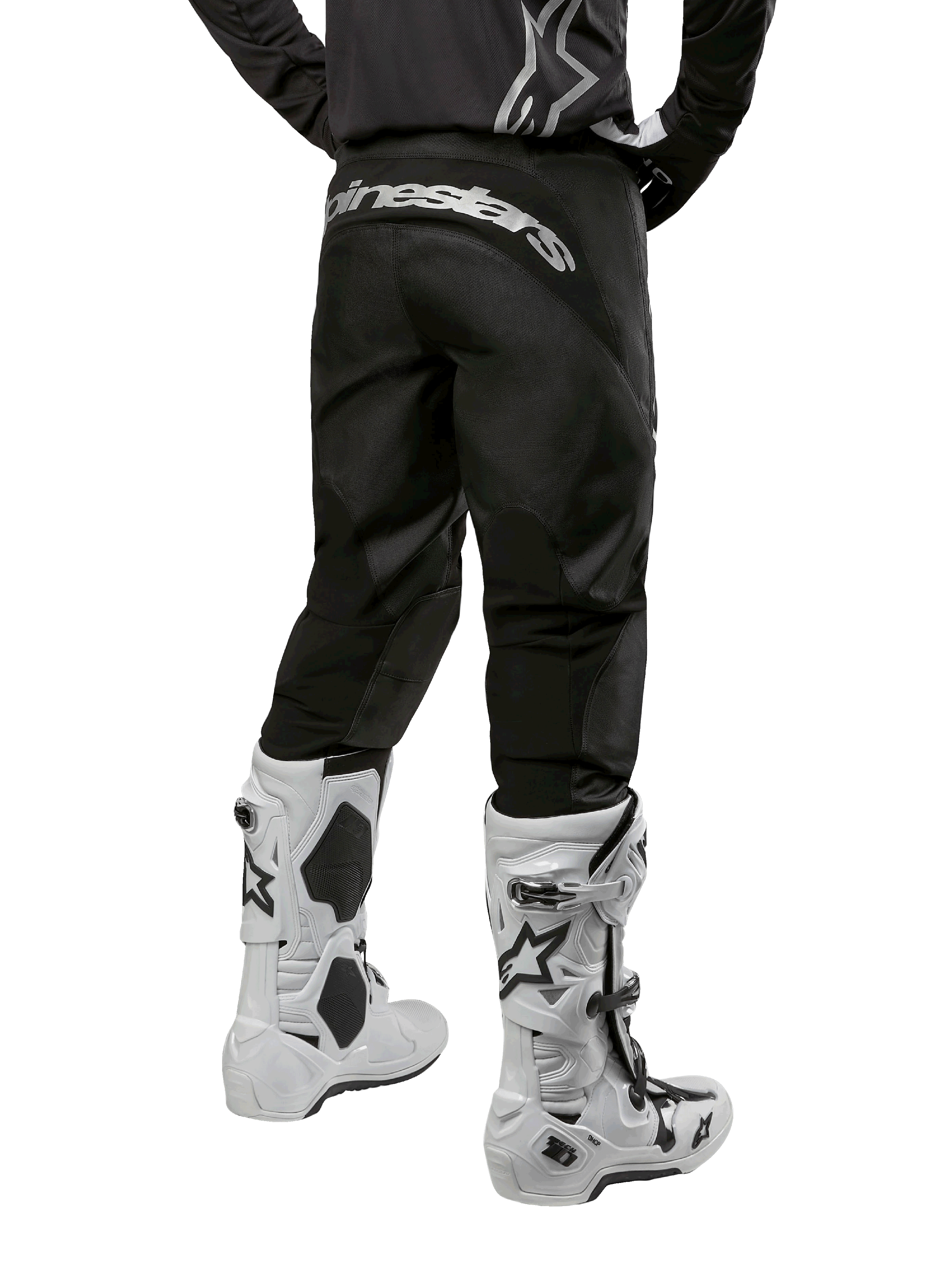 Alpinestars 2024 Fluid Graphite Gear Set, achteraanzicht van zwarte en grijze motorcrossbroek met wit Alpinestars logo op het zitvlak, gedragen met witte en zwarte motorcrosslaarzen, gespecialiseerde off-road race-uitrusting