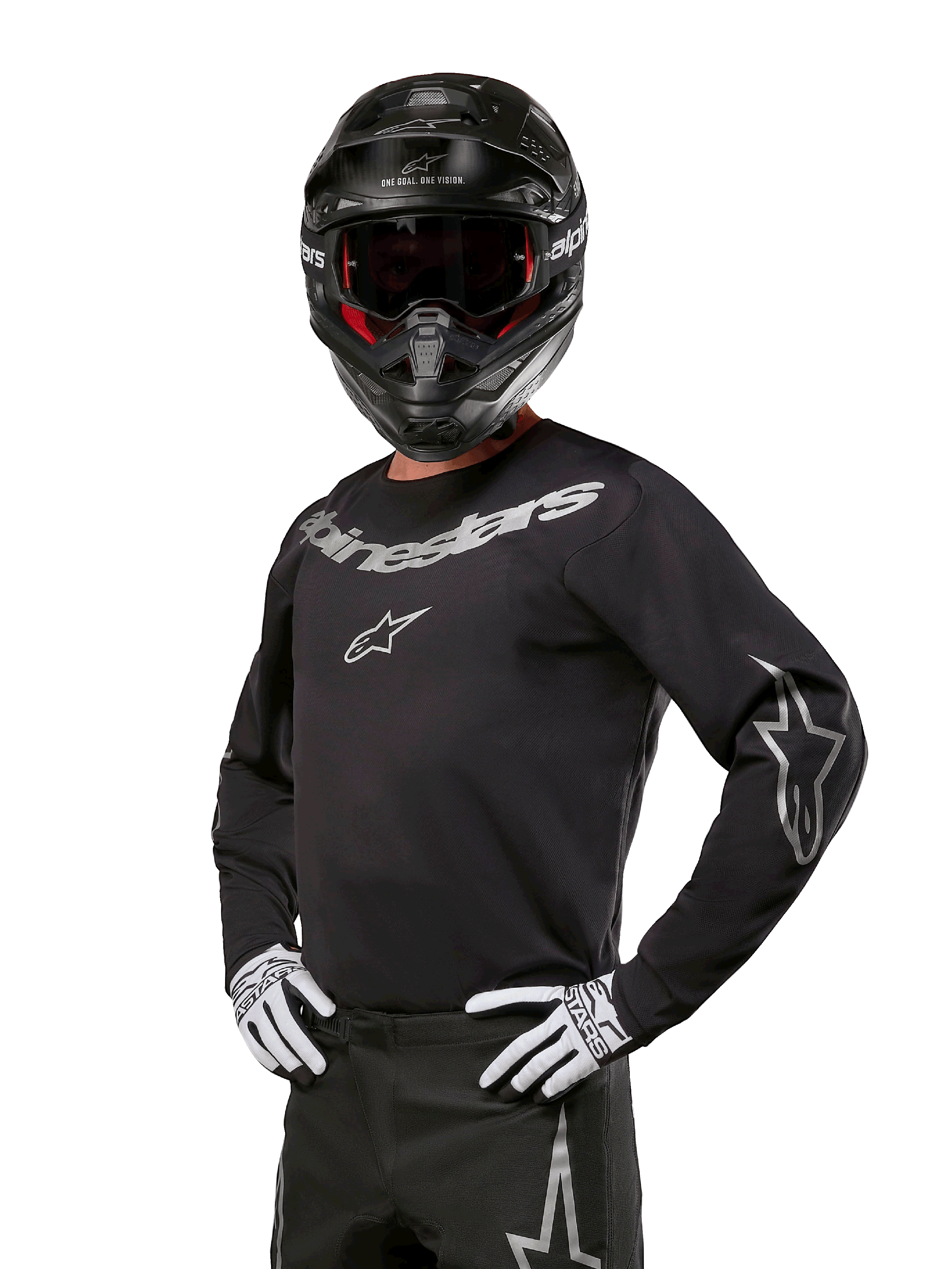 Alpinestars 2024 Fluid Graphite Jersey, zwart met zilver motorcross shirt, lange mouwen met sportieve pasvorm, gedragen met zwarte helm en witte handschoenen, voorzien van zilveren Alpinestars-branding, off-road motoruitrusting