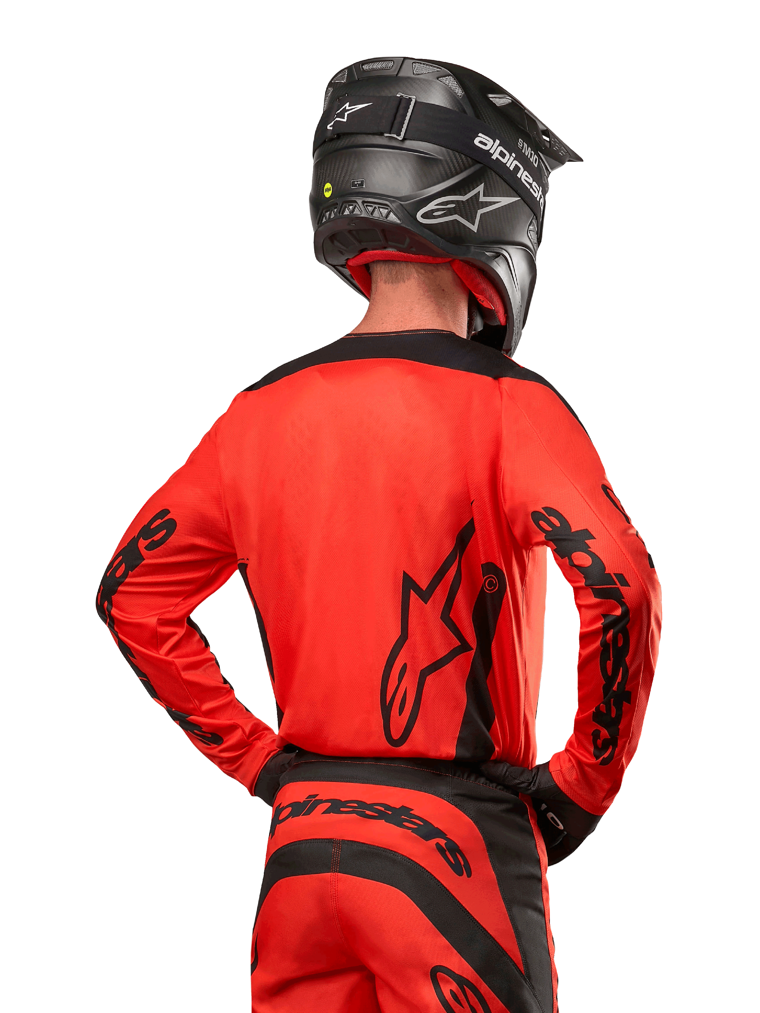 Alpinestars 2024 Fluid Lurv Jersey, motorcross shirt van achteren gezien, Hot Orange en zwart, opvallende Alpinestars-branding op de rug en mouwen, bijpassende crossbroek en zwarte helm, ontworpen voor off-road raceprestaties