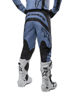 Alpinestars 2024 Fluid Lurv crossbroek, motorcrossbroek, lichtblauw en zwart, achteraanzicht met zwarte versterkte panelen en groot merklogo, gecombineerd met witte en zwarte motorcrosslaarzen, professionele race-uitrusting voor off-road rijden