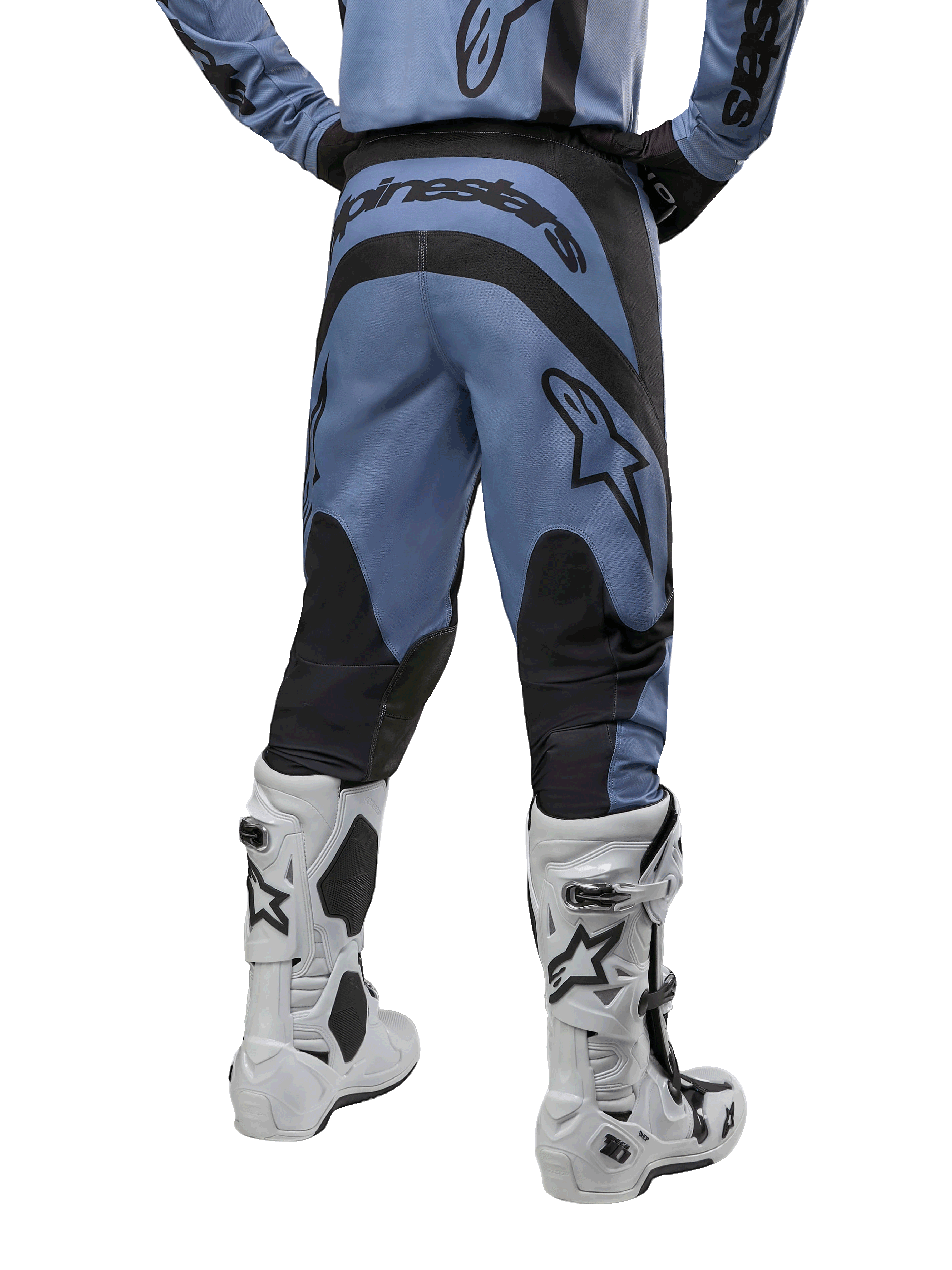 Alpinestars 2024 Fluid Lurv crossbroek, motorcrossbroek, lichtblauw en zwart, achteraanzicht met zwarte versterkte panelen en groot merklogo, gecombineerd met witte en zwarte motorcrosslaarzen, professionele race-uitrusting voor off-road rijden