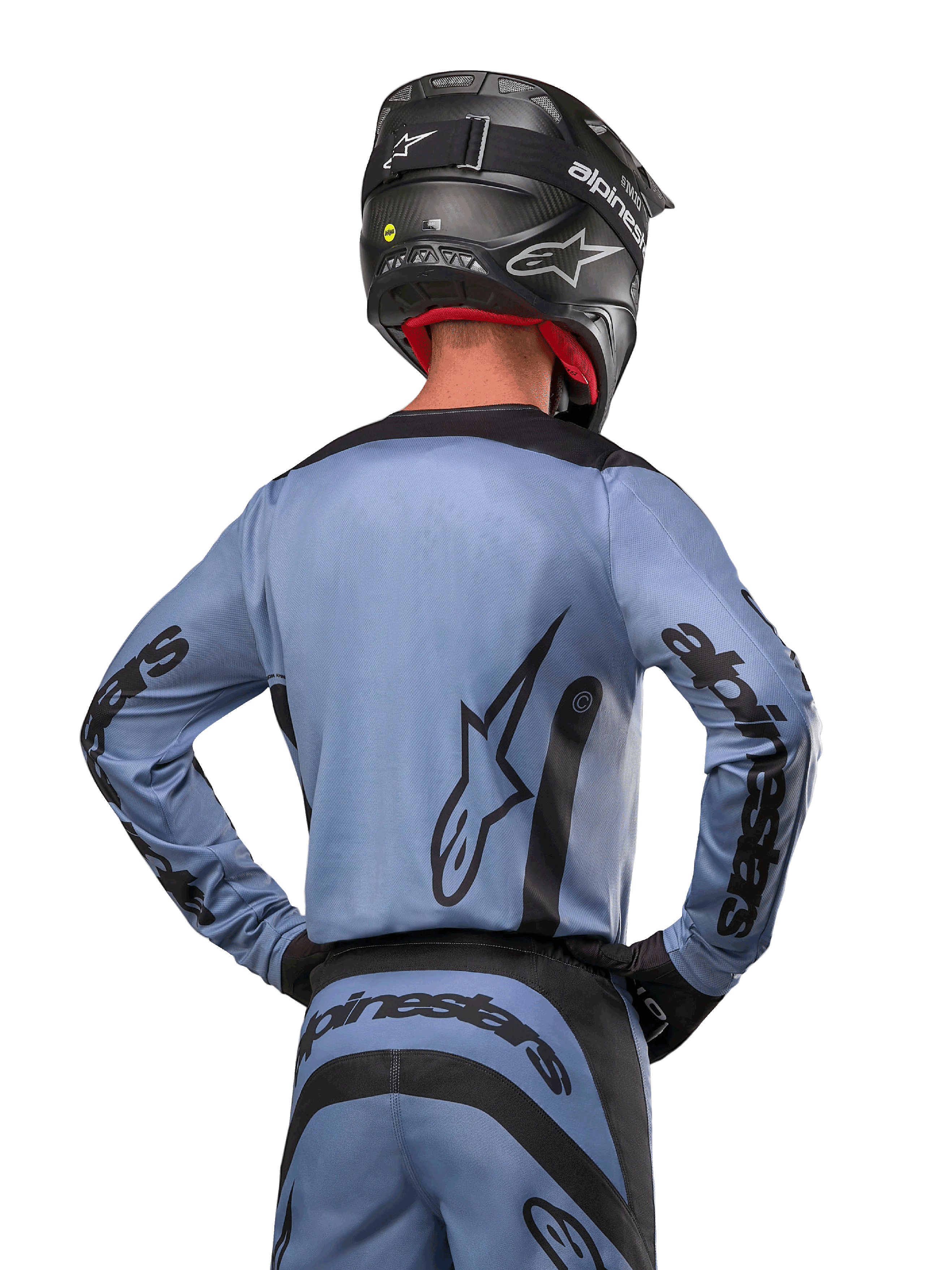 Alpinestars 2024 Fluid Lurv Jersey, motocross shirt, lichtblauw en zwart, achteraanzicht van rijder met groot sterlogo en branding op de mouwen, gedragen met een zwarte helm en bijpassende off-road broek, professionele racekleding
