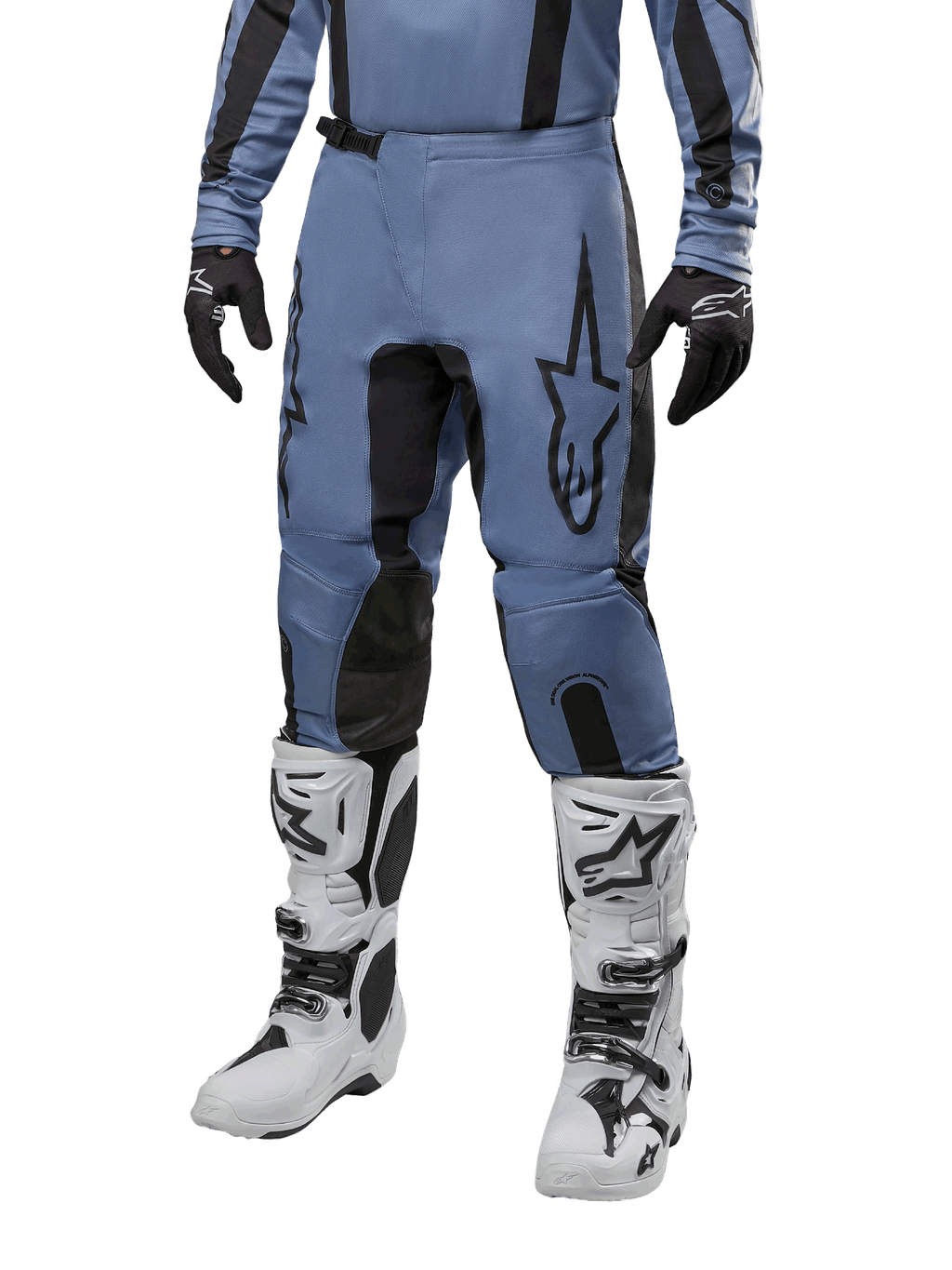 Alpinestars 2024 Fluid Lurv Pants, motorcross broek, lichtblauw en zwart, gedragen met bijpassende jersey met lange mouwen en witte motorcrosslaarzen, voorzien van een prominent zwart sterlogo op de dij en versterkte panelen aan de binnenkant van de knie, vooraanzicht op witte achtergrond