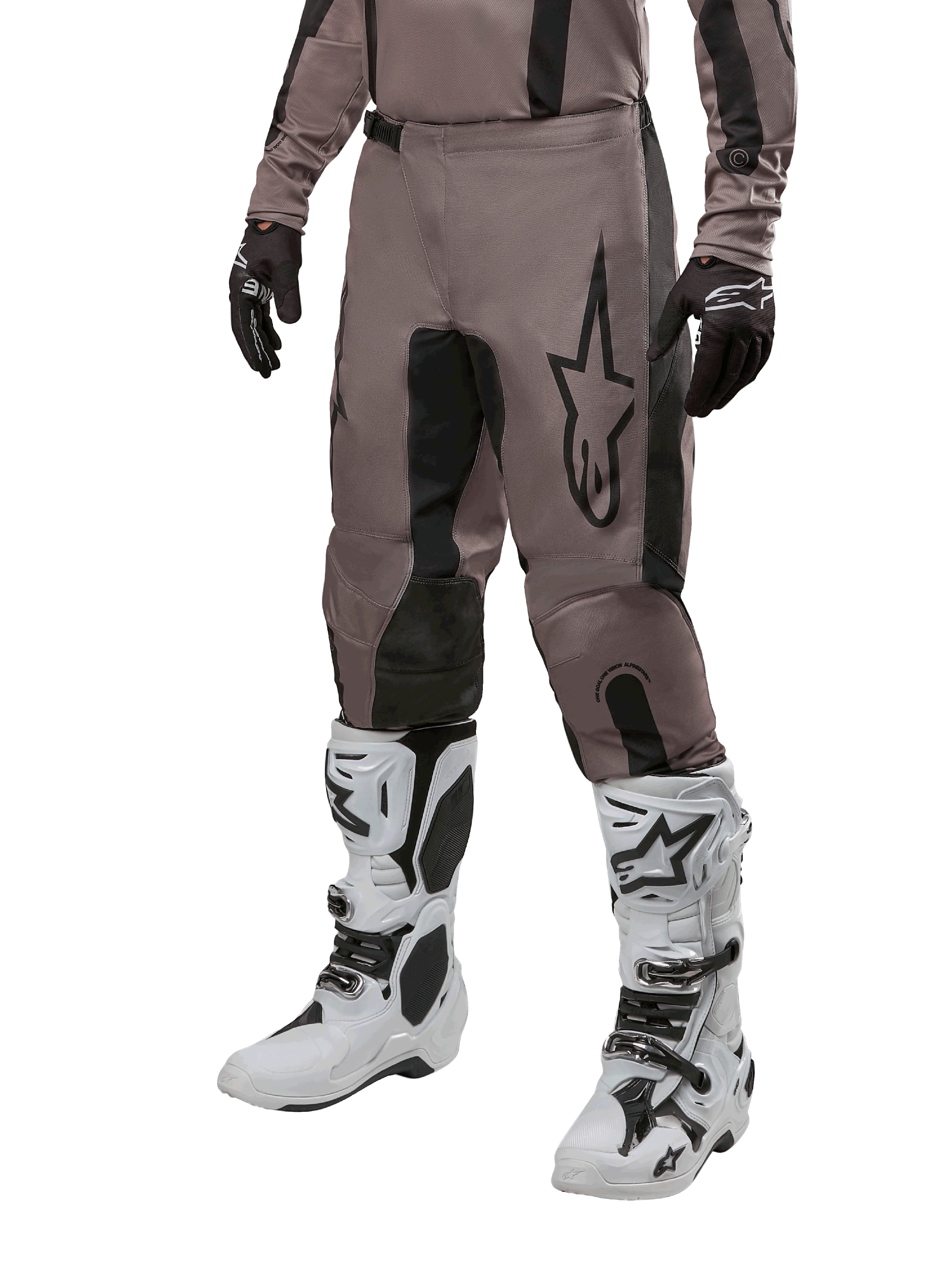 Alpinestars 2024 Fluid Lurv crossbroek, motorcrossbroek, Mud Black en zwart, voorzien van Alpinestars-logo, gedragen met zwarte handschoenen en witte motorcrosslaarzen, sportief ontwerp voor off-road racen