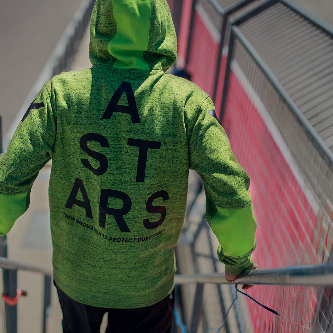 Alpinestars Perpetuate Hoodie, achteraanzicht, limoengroene gemêleerde fleece, grote zwarte ASTARS tekstgrafiek op de rug, casual sportkleding met kleurvlakken en capuchon met trekkoord