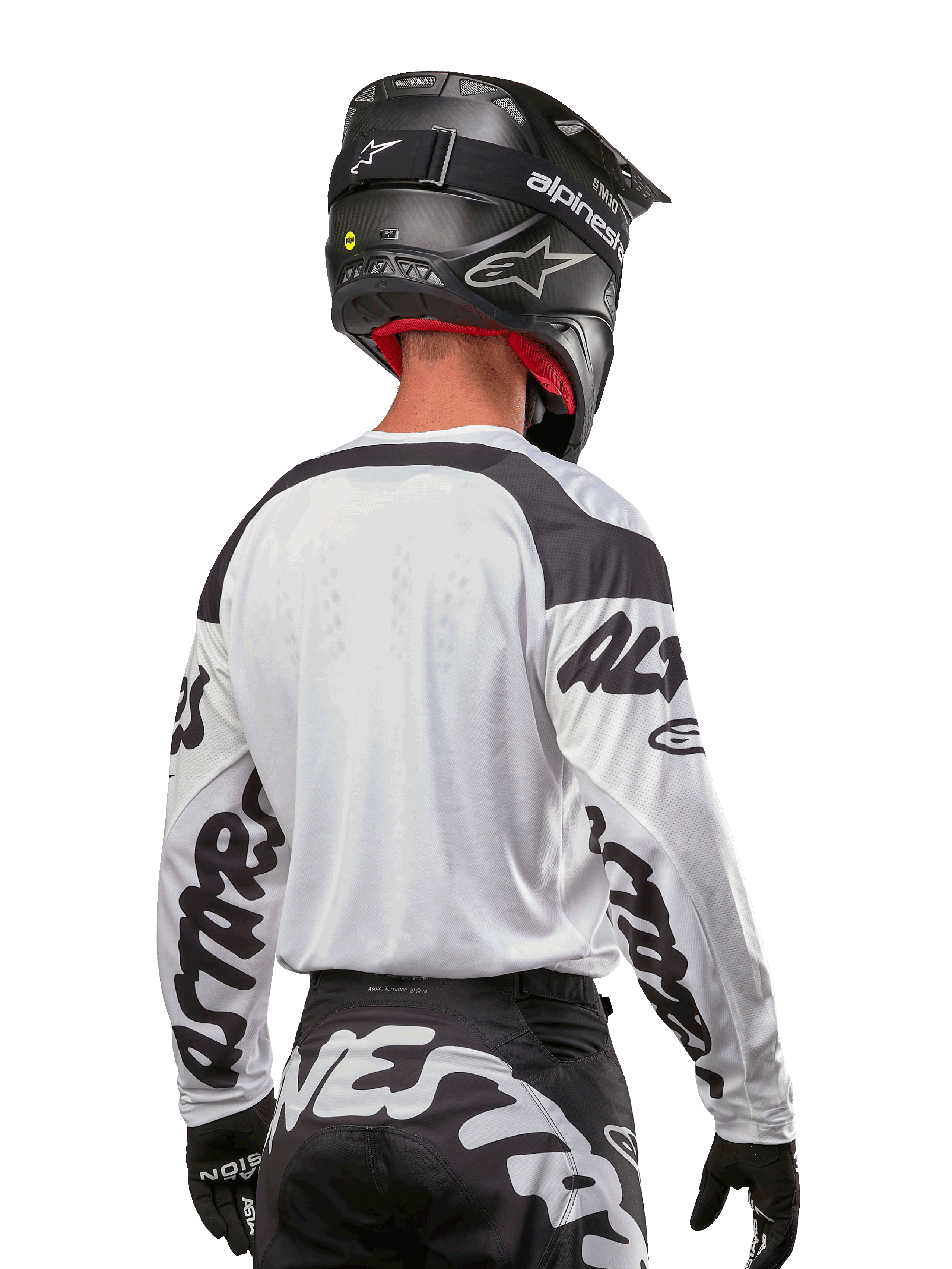 Alpinestars 2024 Racer Hana Jersey, wit en zwart, achteraanzicht met ergonomische pasvorm en opvallende branding op de mouwen, gecombineerd met een zwarte motorcrosshelm en bijpassende zwart-witte broek, hoogwaardige race-uitrusting voor off-road rijden